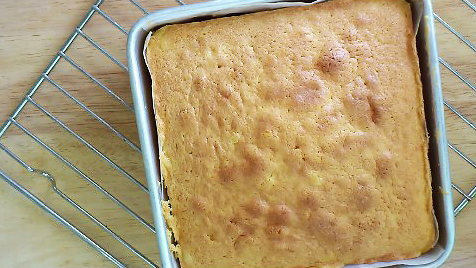 butter cake in cake pan cooling down on a rack